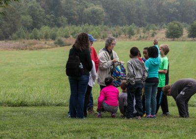 Students visiting historic Belmont hike with a volunteer naturalist during a field trip to the Howard County Conservancy